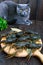 Live crawfish on a wooden tray in the foreground. The gray cat looks closely