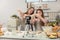 With a live digital camera in the kitchen, mother and daughter smile and have fun while preparing biscuit dough together, daughter