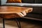 Live edge wooden accent coffee table near sofa close up. Interior design of modern living room. Created with generative AI