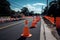 live view of road being repaired with fresh asphalt, traffic cones and barriers in place