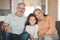 Live your life with love as your guiding principle. a happy senior couple and their granddaughter relaxing on the sofa