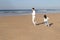 Lively Asian father and daughter playing on beach
