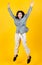 Lively Asian girl wearing casual long sleeve shirt and trousers enjoy exciting play of funny jump up and dance to stretch out and