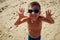 A lively boy in sunglasses smiling at the camera on the beach