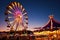 A lively carnival at dusk, Ferris wheel lights. Resplendent.