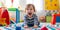 A Lively And Mischievous Toddler Wreaking Havoc In A Colorful Playroom