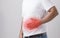 Liver or kidney problem concept : Man holding hand on belly and feeling a pain in liver or . Studio shot isolated on grey