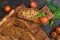 Liver pate with rye bread, tomatoes and spinach on a cutting Board.