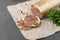 Liver sausage on parchment with parsley on gray background