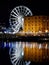 Liverpool docks at night with a big wheel reflected in the river