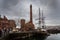 LIVERPOOL, ENGLAND, DECEMBER 27, 2018: People walking along Albert Docks with a frigate floating in the river at one side and the