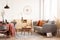 Living and dining room interior with grey couch and table covered with orange tablecloth