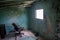 Living room with chair in front of window in the ruined abandoned burned house