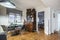 Living room in conventional home with vintage-style root wood bookcase, black circular dining table and matching upholstered