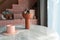 Living room corner decorated with clay ceramic vase and baby pink cup on white marble  table with pink tile stair in the