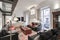 Living room with dark brown leather sofas in a room with balconies facing the street, reddish carpet, sideboards and flat screen