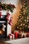 Living room decorated for Christmas with fireplace, Christmas tree and xmas ornaments.