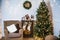 living room decorated for Christmas or New Year. Armchair with knitted plaid, pouf, fireplace, tree, beautiful interior in a