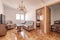 Living room with doors to other rooms and checkerboard parquet floor and three-seater sofa upholstered in fabric with wooden