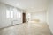 Living room of an empty house with white aluminum twin windows, electric heat accumulators and armored entrance door made of