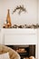 Living room and fire place winter holidays decoration - pine cones and Christmas tree branches garland with string lights and snow