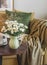 Living room interior coffee table with a bouquet of chrysanthemums, autumn decor, armchair with a cozy  pillows