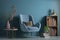 Living Room interior with velvet armchair with books on blue wall background.