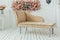 Living room interior wall mock up with pink tufted armchair, pastel pillow, hanging lamp and flowers in vase on empty warm white