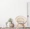 Living room interior with wicker armchair and eucalyptus plant, white wall mock up background