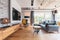 living room with light wooden floor, grey couch and wing back chair and big tv on the wall