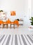 Living room with long table, chairs and orange details. Real photo concept