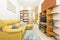 Living room of a rental house with a bookstore in Chennai with a TV and sound system in front of a yellow sofa with chaise longue