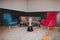 The living room sofa set has a blue, red, brown sofa and a glass table in the middle. For placing glasses and flowers adorned for