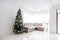 Living room space, comfortable sofa and christmas tree in large suite. Contemporary designer mansion