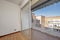 Living room of a white-walled house with a terrace with aluminum and glass windows and white-painted railings