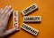LLC - Limited liability company. Wooden cubes with word LLC. Businessman hand. Beautiful orange background. Business and LLC