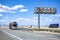 Loaded car hauler big rig semi truck with semi trailer with cars standing on the road shoulder beside highway with running another