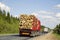 Loaded timber truck rides on the highway. Road transport