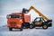 The loader loads the snow into the dumper.