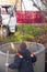 A loader lowers a concrete ring into a dug hole to build a septic tank. A worker installs a sewer into the ground