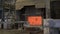 Loader mixes molten aluminum in a blast furnace. Aluminium foundry furnace loaded with metal. Red hot flames glowing and