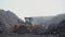 A loader picks up coal in a ladle in an open coal warehouse