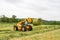 Loader tractor moving a round bale from field