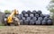 Loader tractor stacking round bales in a stack