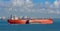 Loading anchored oil supertanker via a ship-to-ship oil transfer