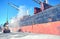 Loading cargo of cement clinker in bulk carrier by ships cranes in the port of Izmir, Turkey.