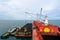 Loading coal from cargo barges onto a bulk vessel using ship cranes.