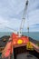 Loading coal from cargo barges onto a bulk vessel using ship cranes.