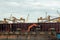 Loading coal from cargo barges onto a bulk vessel using ship cranes.