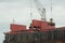 Loading coal from cargo barges onto a bulk vessel using ship cranes.